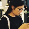 スマホを見ながら結婚について考える女性