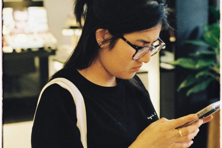 スマホを見ながら結婚について考える女性
