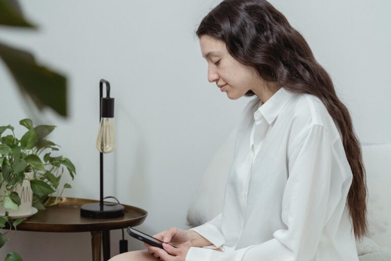 ベッドでスマホを見る女性