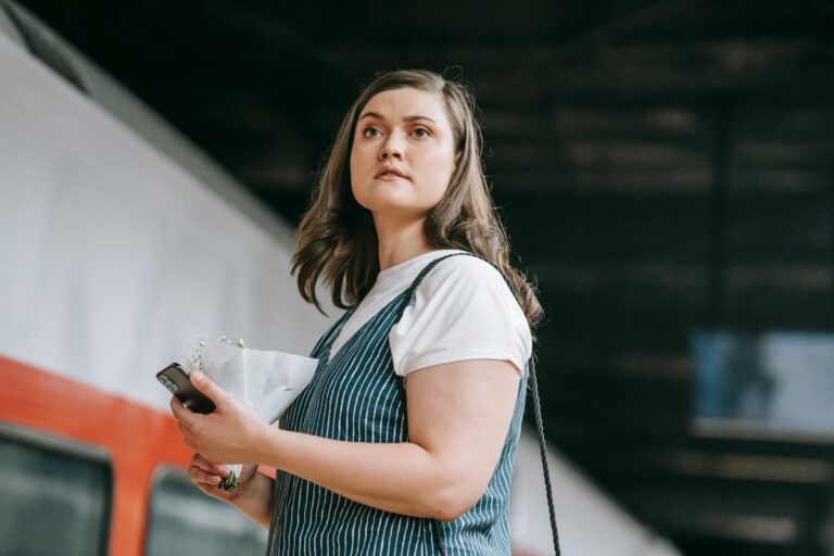 スマホを見ながら連絡を待つ女性