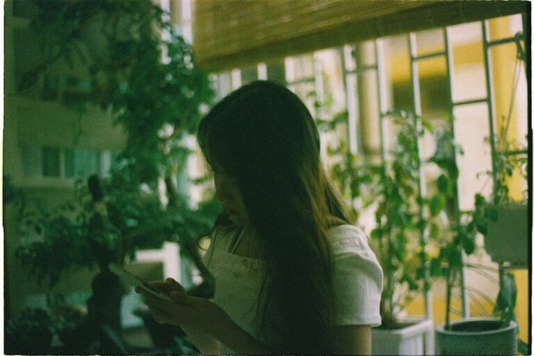 スマホを見ながら考える女性